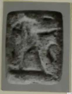 Blurred photograph of a small stone seal with a carved figure in relief