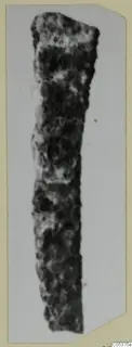 Corroded iron tool from Amathus, an elongated object that tapers toward its lower end.