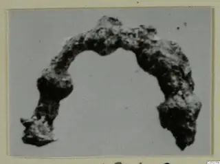 Corroded bronze loop from Amathus, bent into an open arc with thicker, uneven ends