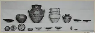 Pottery vessels from Amathus, Tomb 2, set out in two rows on shelves against a plain backdrop