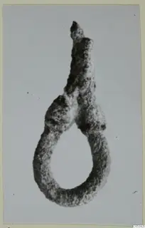Corroded silver loop-shaped find from Amathus, with a tapering stub rising from the top of the loop