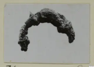 Corroded curved metal object from Amathus, shown against a white background