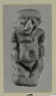 Small figurine from Amathus of a squat figure with a broad head, large nose and arms held against the body.