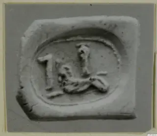 Impression of a seal from Amathus showing a small animal-like figure and an upright sign inside an oval border