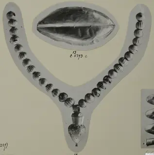 Photo mount showing a bead necklace with a jug-shaped pendant, and a flat oval object above it