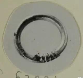 Ring-shaped metal object from Marion, photographed on a pale mount.