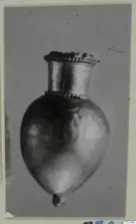 Single small metal object with a flared neck and rounded body, shown against a grey backdrop