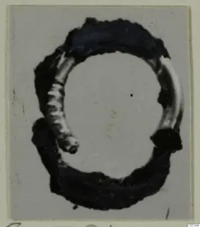 Hair-ring of gilded bronze from Marion Tomb 38, photographed close up on a grey card mount