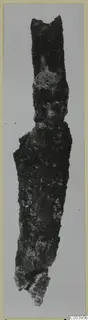 Corroded iron tool from Amathus, shown upright against a grey background.