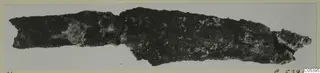 Corroded iron tool fragment from Amathus, shown lying horizontally on a pale background