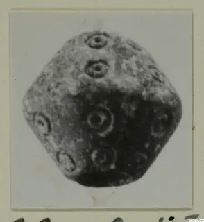 Many-faced stone object with ring-shaped decoration on its faces, from Amathus, photographed on a mounted card