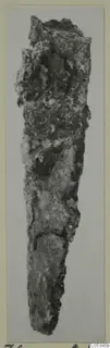 Corroded iron tool from Amathus, long and tapering to a point, photographed upright on a mounted card