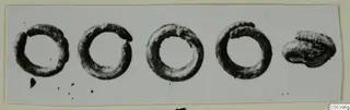 Four corroded rings and one irregular lump of metal lying in a row, from Marion.