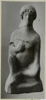 Terracotta figurine of a human figure with a rounded head and one arm bent across the chest, cracked