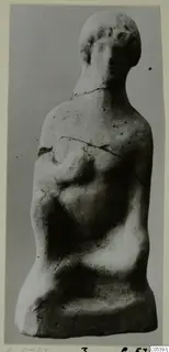 Terracotta figurine of a human figure with a rounded head and one arm across the chest, from the Marion finds
