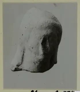 Terracotta head from Tomb 20 at Marion, photographed from a three-quarter view.
