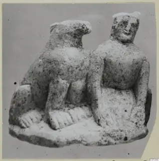 Limestone statuette of two figures side by side on a shared base