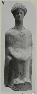 Terracotta figurine of a standing female figure with curled hair and arms held across the body, from Marion tombs