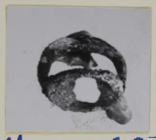 Corroded silver ring, shown on a pale background, mounted on a card.