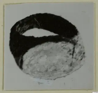 Silver ring, photographed close up and mounted on a card with a cream border.