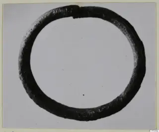 Silver bracelet, a plain closed ring of dark metal shown against a light background.