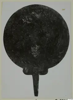 Round metal disc with a short tang from Marion Tomb 38, dark and corroded