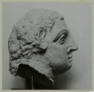 Head in profile facing right, from Mersinaki, with wavy hair and a broken lower edge