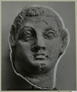 Sculpted head with short hair, large heavy-lidded eyes and a chipped nose, pale stone, on a dark stand, from Mersinaki