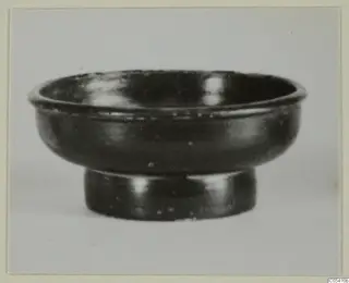 Black glazed ware bowl with a short ring foot, seen from the side