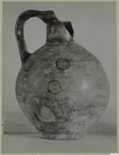 Pottery Black-on-Red jug with a single loop handle and concentric circle motifs on its round body