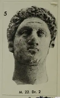 Head with curly hair and a broken-off neck, shown in a photograph mounted on a card