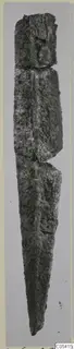 Corroded iron knife or blade from Amathus, standing upright with its point at the lower end.