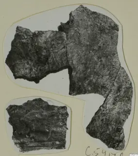 Two corroded metal fragments from Amathus, photographed on a white card mount.