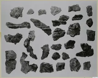 Corroded iron weapon fragments from Amathus tombs 1–9, laid out in rows on a pale background.