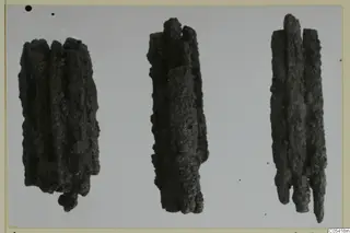 Three corroded iron weapons from Amathus, lying side by side on a pale background.