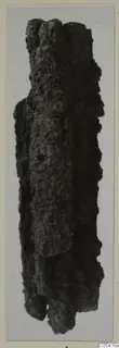 Heavily corroded iron weapon fragment from Amathus, standing upright.