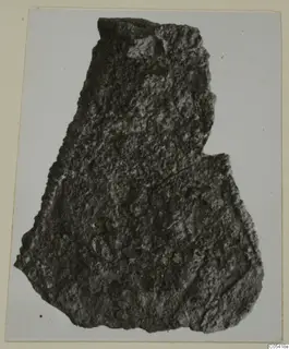 Corroded iron fragment from Amathus, photographed on a cream card mount