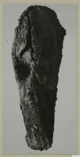 Heavily corroded iron tool from Amathus, elongated with a rounded socket-like opening near the upper end.