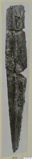 Corroded iron weapon blade, photographed upright against a pale grey card mount