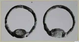 Two silver rings with flat oval settings, side by side on a pale background.