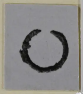 Open bronze ring of personal adornment on a grey card.