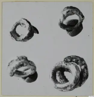 Four corroded silver rings on a grey background, photographed from different angles.