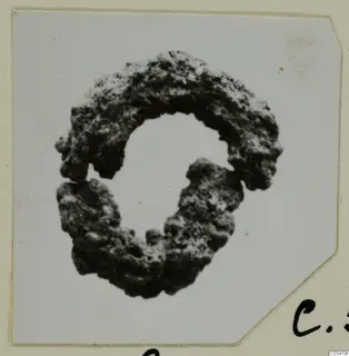 Silver hair-ring, an open ring with a pitted, corroded dark surface, on a pale card mount