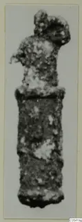 Corroded silver object with a rounded knob-like top and a plain cylindrical body, photographed against a pale background.