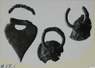 Bronze mountings from Marion Tomb 58: a heart-shaped plaque, a ring, a hooked fragment and a curved strip.