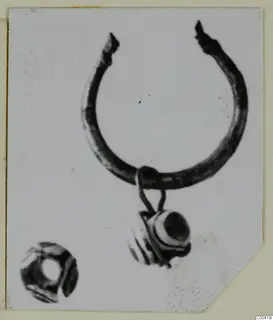 Silver ring with a bead pendant on a loop, and a separate small bead at lower left