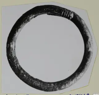 Bronze ring from Marion, a dark corroded hoop with ribbed decoration at one end.