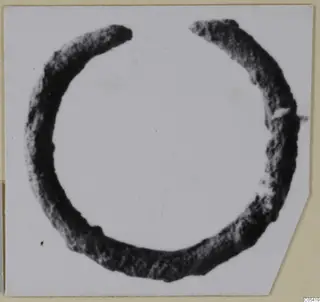 Open bronze ring with a gap at the top, photographed on a pale card from Marion.