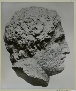 Limestone head of a figure facing right, with curled locks of hair, from Mersinaki
