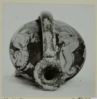 Round pottery vessel with a tall strap handle and a wide spout, decorated with large painted figures in dark paint